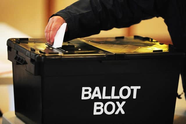 A voter places a ballot paper in the ballot box at the polling station at Market Hall in Swadlincote, Derbyshire, as the General Election got underway across the UK.