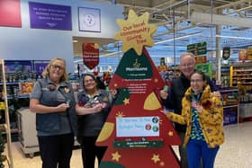Morrisons community champion Alison Whitburn shows Charlie and Grace Sims from St Peter and St Paul's Pantry in Rustington how the Giving Tree works
