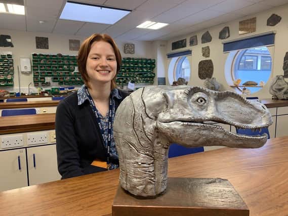 Ceri with the side of the sculpture which shows her interpretation of what the Velociraptor may have looked like 