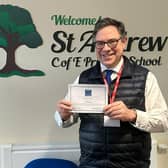 Horsham MP Sir Jeremy Quin receives a headteacher's certificate after helping St Andrew's School in Nuthurst to avoid a power cut