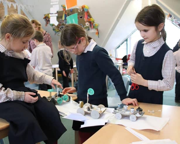 Children at Highfield and Brookham Schools use their moon buggies to test the strength of their bridge
