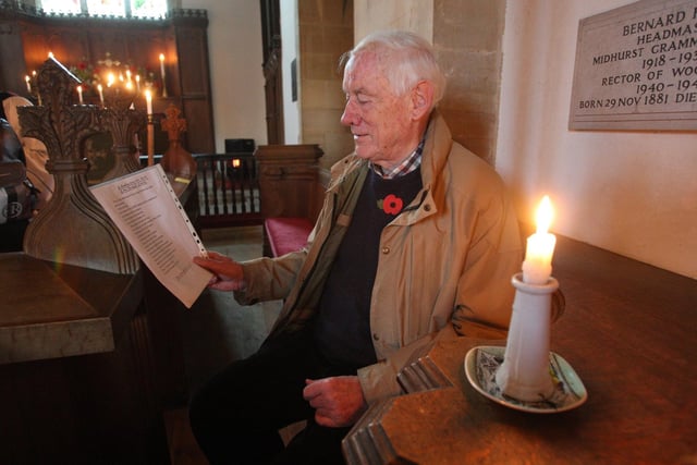 DM22110366a.jpg. Remembrance Sunday service at Woolbeding church. Parishioner Peter Collins during the candlelit service. Photo by Derek Martin Photography and Art.