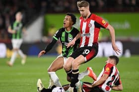 BRENTFORD, ENGLAND - APRIL 03: Joao Pedro of Brighton & Hove Albion is tackled by Kristoffer Ajer (C) and Vitaly Janelt of Brentford (R) during the Premier League match between Brentford FC and Brighton & Hove Albion at Gtech Community Stadium on April 03, 2024 in Brentford, England. (Photo by Mike Hewitt/Getty Images)