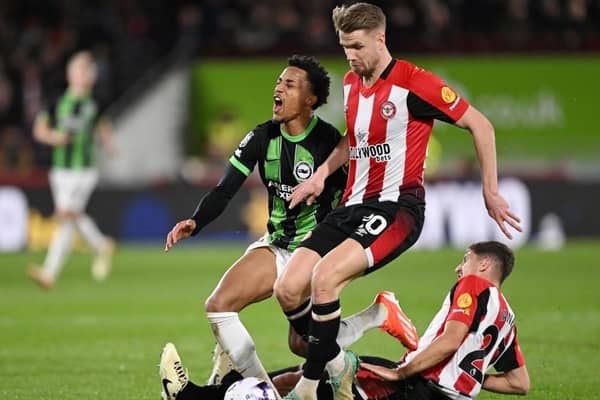 BRENTFORD, ENGLAND - APRIL 03: Joao Pedro of Brighton & Hove Albion is tackled by Kristoffer Ajer (C) and Vitaly Janelt of Brentford (R) during the Premier League match between Brentford FC and Brighton & Hove Albion at Gtech Community Stadium on April 03, 2024 in Brentford, England. (Photo by Mike Hewitt/Getty Images)
