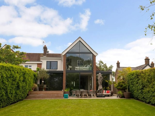 The garden is mostly laid to lawn and is enclosed by mature clipped hedges