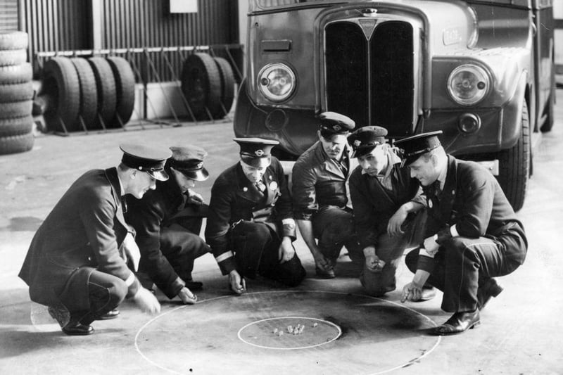A group of Crawley busmen have a practice game of marbles in their bus garage on 9th March 1938.