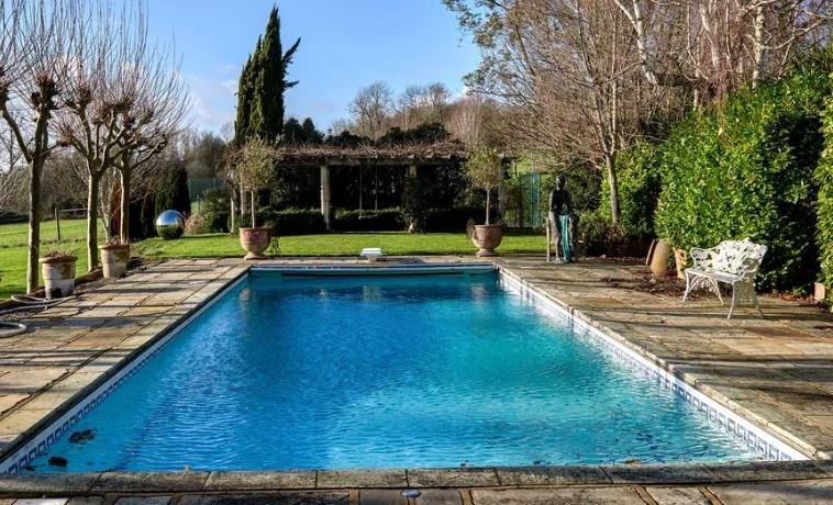 The swimming pool is an idyllic setting within the well-kept gardens