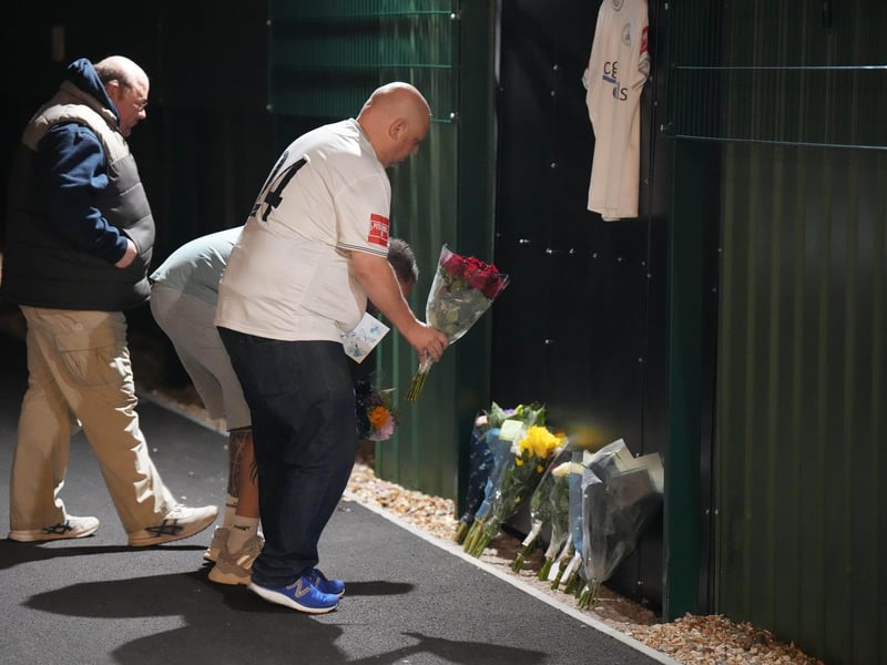 Chichester City FC and former Arsenal academy striker Billy Vigar has died after sustaining a "significant brain injury".
Vigar, 21 and born in Worthing, was injured during a game at Wingate and Finchley on Saturday in the Isthmian League Premier Division.
It is thought the injury was caused when he collided with a concrete wall, but the club has not confirmed this.
Vigar's family said on Thursday they were "devastated that this has happened while he was playing the sport he loved".
"After sustaining a significant brain injury last Saturday, Billy Vigar was put into an induced coma," the family said.
"On Tuesday, he needed an operation to aid any chances of recovery. Although this helped, the injury proved too much for him and he passed away on Thursday morning.
"The responses to the original update show how much Billy was loved and thought of within the sport." : Floral tributes to Billy Vigar are left at Chichester City FC