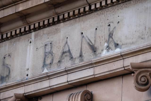 The remains of a sign over a former branch of Barclays Bank, now closed