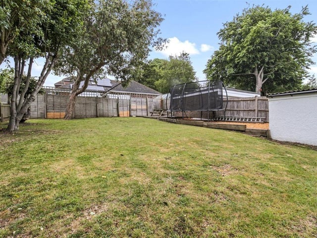 The substantial back garden is a peaceful setting with mature trees