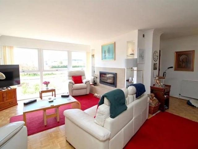 The lounge area features wood block flooring and a wood burning stove with tiled surround.