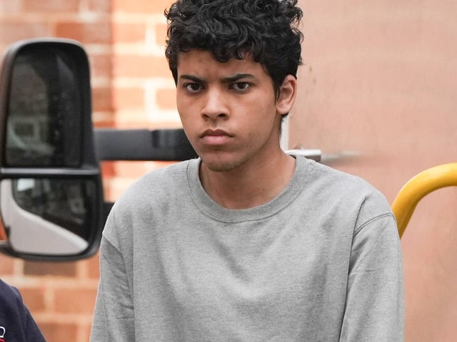 A Sussex teenager accused of murdering his father and attempting to kill a woman and a boy has been pictured arriving at court in handcuffs.