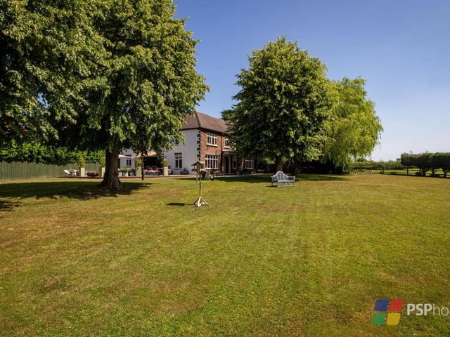 The home sits on an 0.8 acre plot with level lawn, established borders and trees