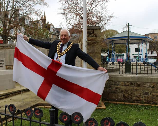 Horsham District Council chairman David Skipp raises the St George's flag in Horsham town centre