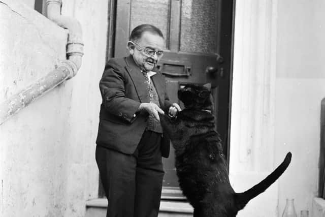 Henry Behrens dancing with his pet cat in the doorway of his Worthing home. Picture: Harry Kerr/BIPs/Getty Images