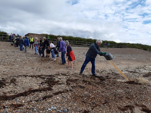 A bucket chain of volunteers from Ferring History Group and Ferring Conservation Group, including Worthing West MP Sir Peter Bottomley, form a bucket chain to bail out nine inches of water from the Ferring pillbox