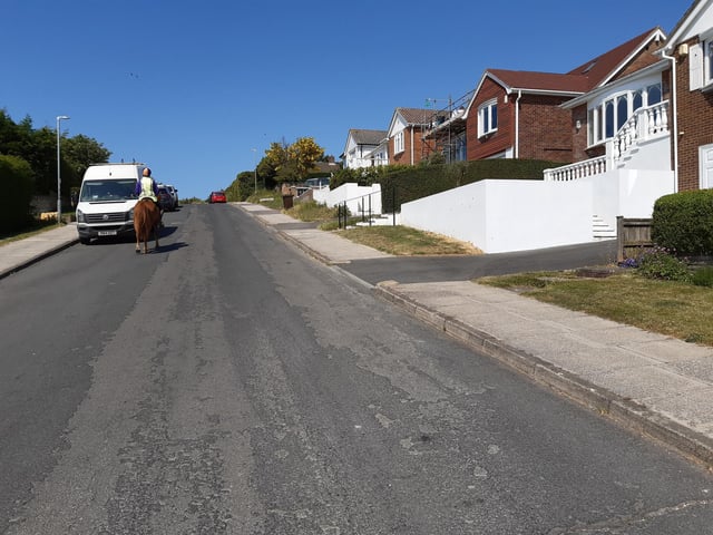 You will pass some shops on your left and continue uphill to Bishopstone Drive, where you turn left.