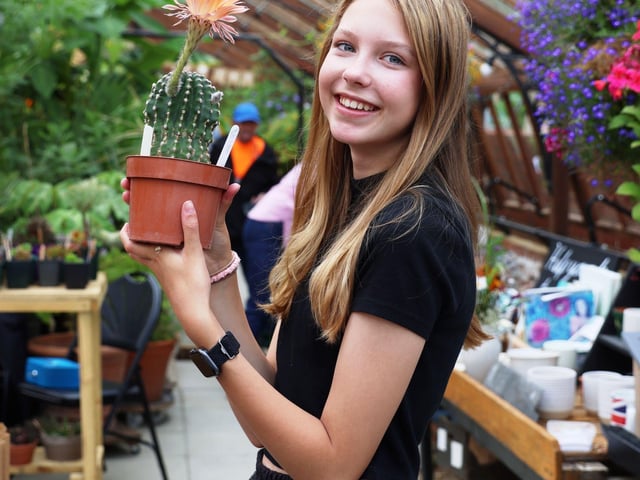 Emilia Hamilton with a cactus in bloom.