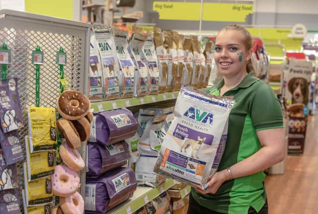 Charlotte Jenkins holds a packet of dog food at Pets at Home in Bexhill-on-sea after the store was refurbished.