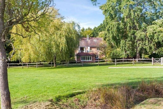 The gardens include a paddock and outbuildings in a private part-wooded rural setting