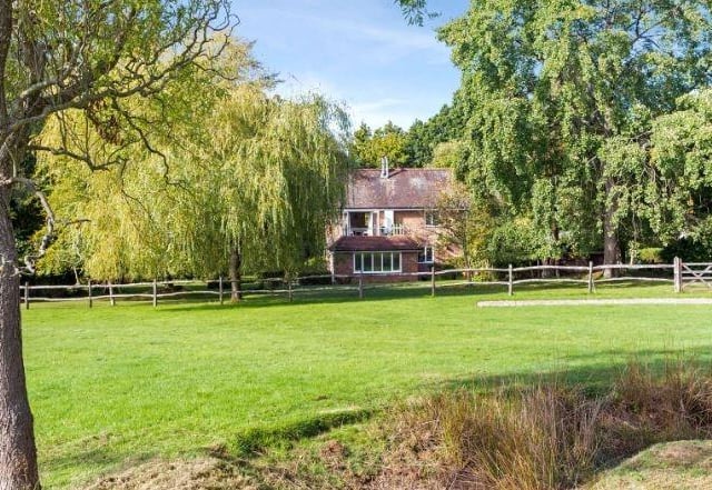 The gardens include a paddock and outbuildings in a private part-wooded rural setting