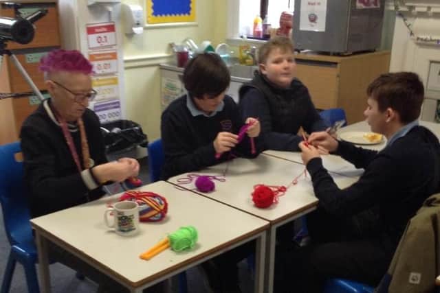 Students knit warm gear to help the homeless