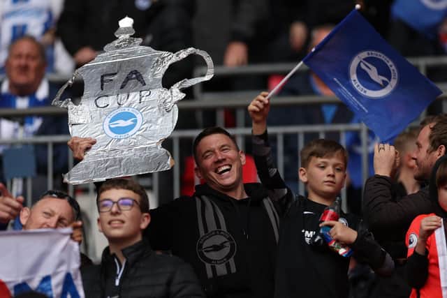 A Brighton fan holds up a tin foil FA Cup in the crowd ahead of the English FA Cup semi-final football match between Manchester United and Brighton and Hove Albion at Wembley Stadium in north west London on April 23, 2023. (Photo by Adrian DENNIS / AFP) / NOT FOR MARKETING OR ADVERTISING USE / RESTRICTED TO EDITORIAL USE (Photo by ADRIAN DENNIS/AFP via Getty Images)