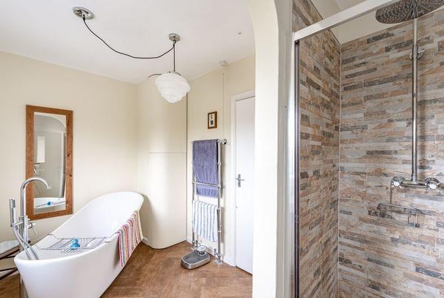 The good size family bathroom is fitted with a freestanding bathtub and separate walk-in shower cubicle.