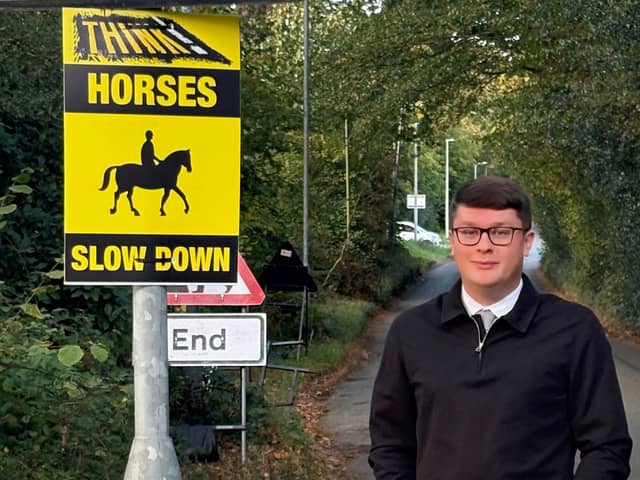 Cllr Connor Winter by one of the new signs