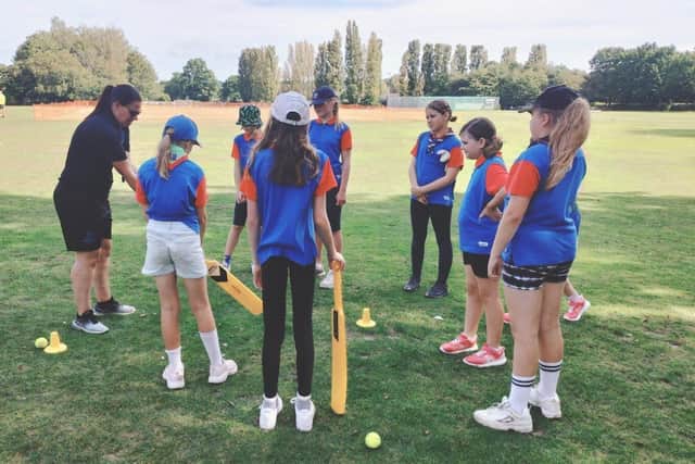Guides being coached on how to use a cricket bat