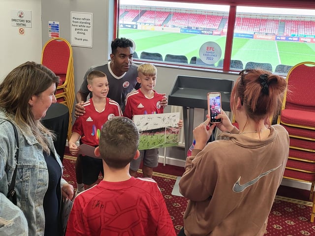 Kevin Betsy poses for a photo with fans