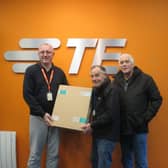 Tony Ash, TE Hastings Logistics, presents Joe and Vern, St. Michael's Hospice with one of the boxes of masks.