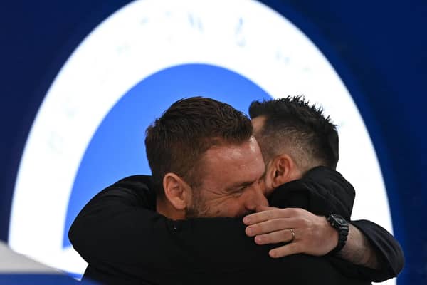 Roma's head coach Daniele De Rossi is greeted by his compatriot Roberto De Zerbi, manager of Brighton and Hove Albion (Photo by GLYN KIRK/AFP via Getty Images)