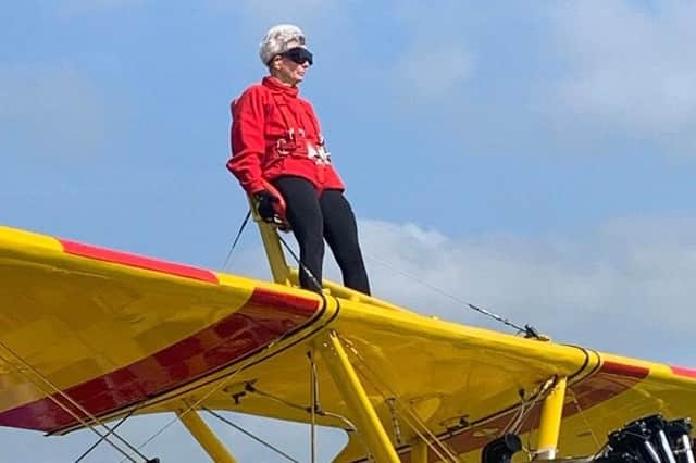 Wendy Whelan, aged 75, gracefully wing-walking on a vintage biplane, defying age and inspiring all.