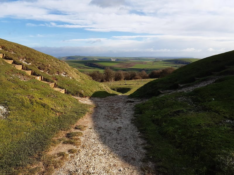 As you carry on your journey around, it is the second gap in the ramparts you are looking for. Steps go up either side to the top of the ramparts but we are taking the central path through and down to leave Cissbury Ring.