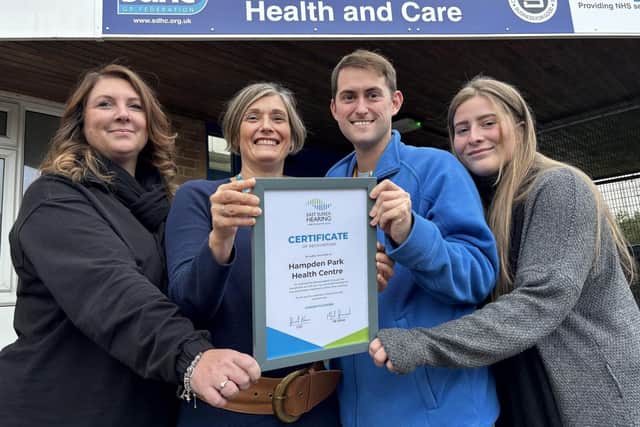 South Downs Health &amp; Care Ltd staff receive their award from East Sussex Hearing's Arron Polton