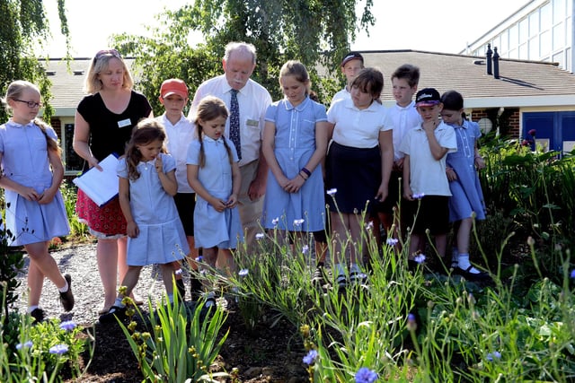 Petworth Primary School pupils proudly show the RHS judges the sensory garden they planted with In Bloom volunteers and the water feature they had built from recycled materials