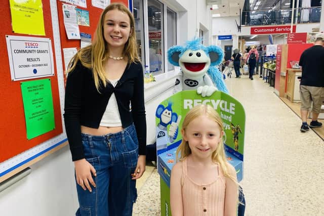 Children with Busta in Tesco beside the Recycle to Read Collection Bins
