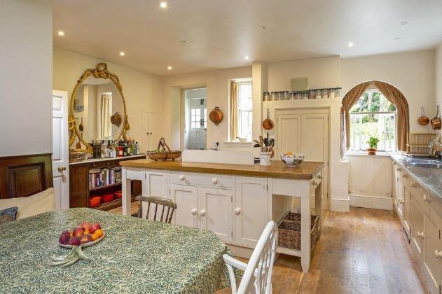 To the rear of the house lies a cloakroom, and the kitchen/breakfast room, with fitted seating for a breakfast table, a central island with an oak worktop and a range cooker; it is served by a scullery, with cellar access.