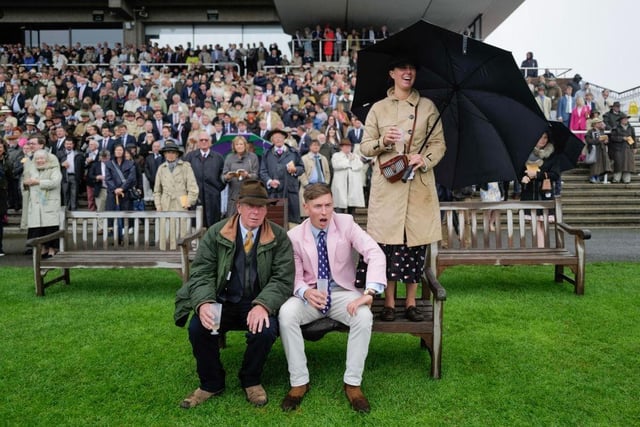 CHICHESTER, ENGLAND - AUGUST 02: Racegoers cheer on their selection as they sit on a wet bench as rain falls during The Whispering Angel Oak Tree Stakes at Goodwood Racecourse on August 02, 2023 in Chichester, England. (Photo by Alan Crowhurst/Getty Images):Images from a murky second day at Glorious Goodwood by Alan Crowhurst of Getty and Clive Bennett