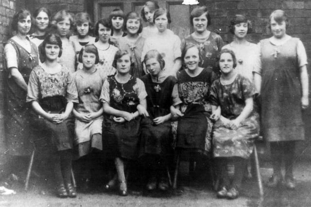 'Umbrella Girls' at Samuel Fox and Co. Ltd in Sheffield, with the machine shop in the background, in 1925. Front row l to r: Nellie Butcher; Nellie Crownshaw; Anna Dyson; Clarice Pearson; Ada Bradwell; Nellie Barraclough. Middle row l to r: Dorothy Jackson; Florice Stuart; Beatrice Harrison; Ethel Hague; Mira Hampshire; Edith Stafford; Lilly Gillet; Eva Slater; Anna Arthur; Ann Stafford. Back Row l to r: Florrie Gaskell; Ruth Gill