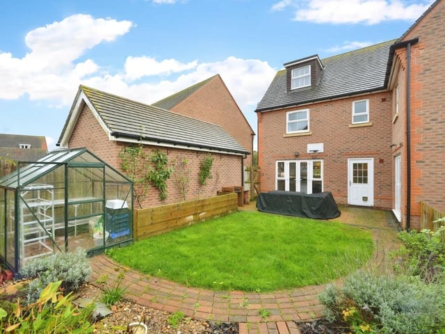 The rear garden includes a patio with a lawned area, a decked area and a pond as well as an electric car charging point