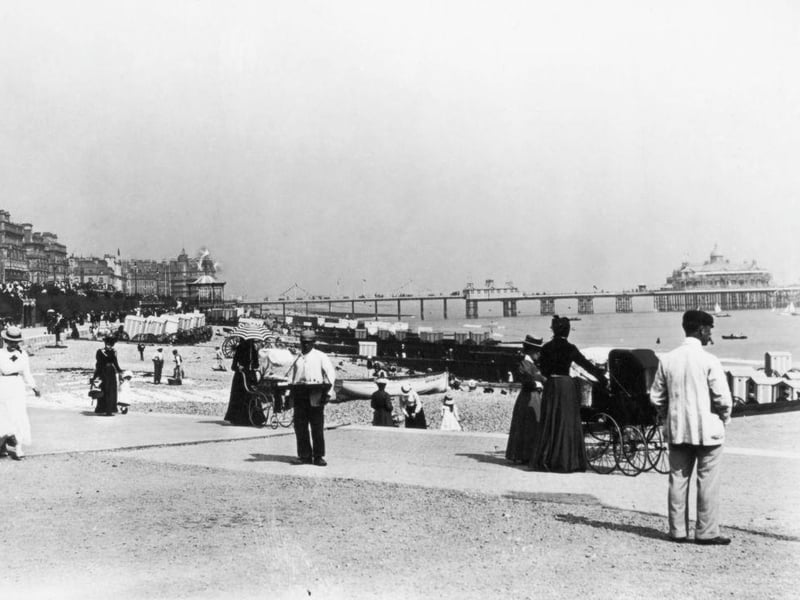 Holidaymakers on the sea front at Eastbourne, with Eastbourne pier in the background, circa 1895.