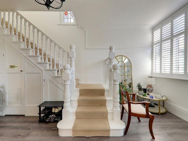 The spacious entrance/reception hall has a storage cupboard under the stairs and a cloaks cupboard