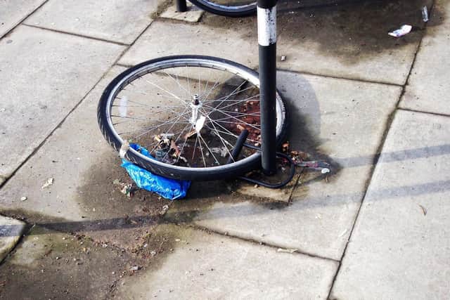 A bicycle wheel remains locked to a bike rack after the rest of the bike has been stolen
