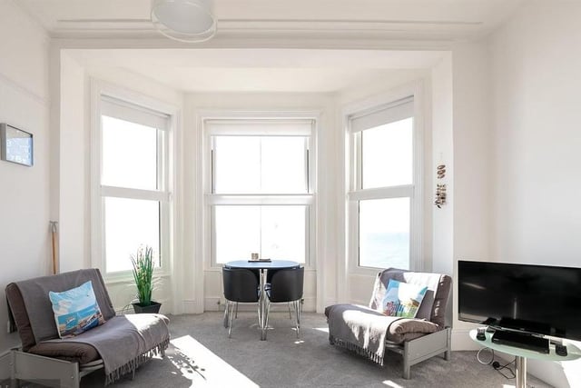 The living room has a bay window overlooking the seafront