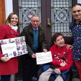 Ashley Price, president of Lewes Chamber of Commerce, presents a cheque to Bevern Trust resident JP, accompanied by Dionne and Maciek