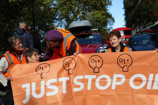 Members of the environmental activist group Just Stop Oil hold a banner as they block Park Lane, in central London, on Sunday | Picture: Getty