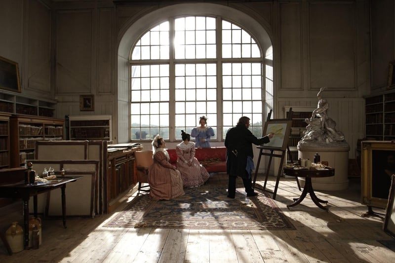 Mr Turner Timothy Spall as Turner paints in the Old Library Petworth House watched by mother and daughter group credit Simon Mein and Thin Man Films