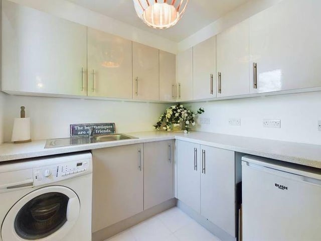 The utility room has spaces for a washing machine and additional fridge